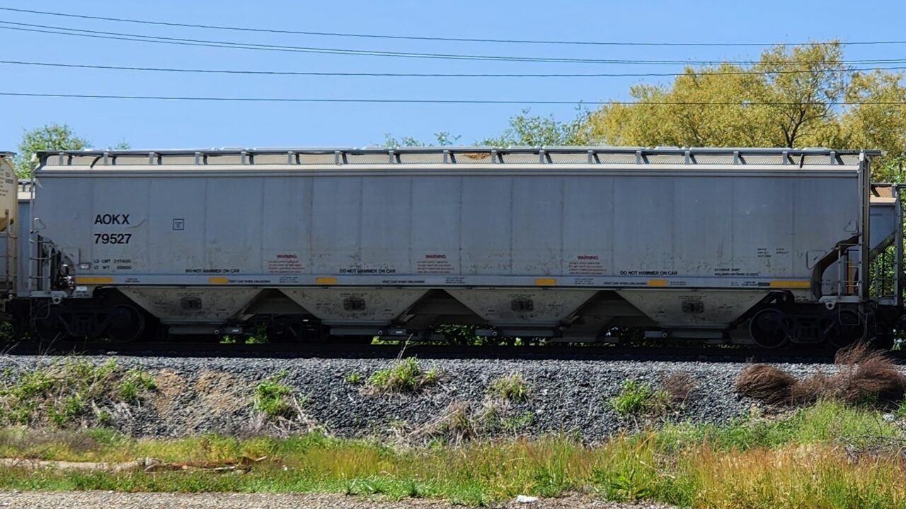 A 4 BAY COVERED HOPPER WITH MINIMAL WEAR ON IT