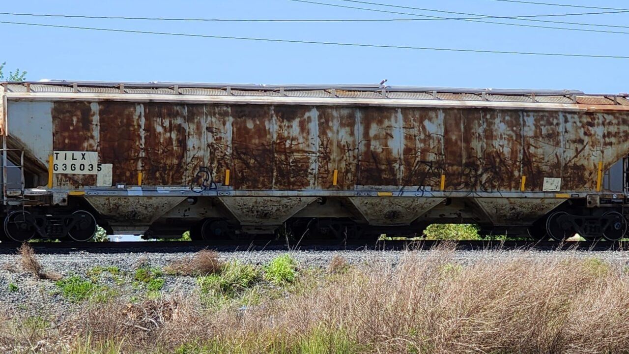 A VERY RUSTY 4 BAY COVERED HOPPER