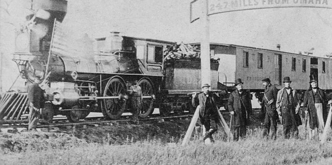 AN OLD HISOTRICAL PHOTO OF A UNION PACIFIC LOCOMOTIVE DURING CONSTRUCTION OF THE FIRST TRANSCONTINENTAL RAILROAD.