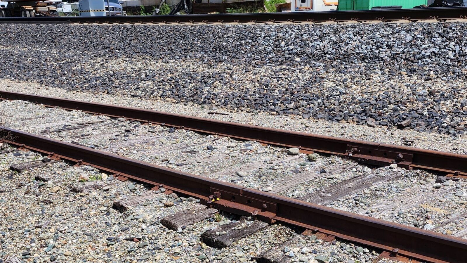 A prototype mainline ballast shoulder next to a team track spur. Note the lighter sub ballast color showing through the actual track ballast.